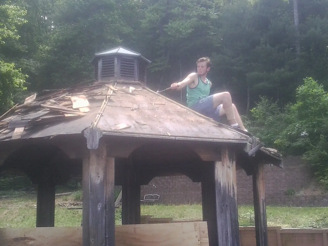 Tearing the old roof off a wooden gazebo before new shakes in Goldvein