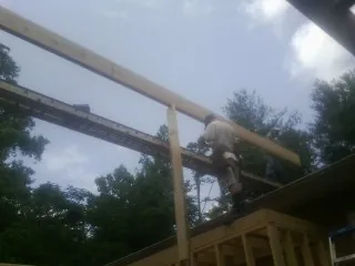 Carpenter setting a ridge beam over a new addition frame — Ice Dam Removal by Roofing Brothers in Goldvein