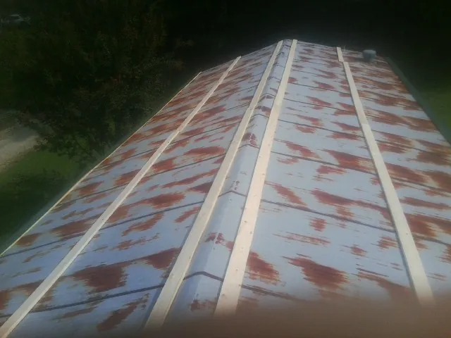 Rusted metal roof panels with new wood purlins before replacement — Storm Damage Roof Repair in Goldvein by Roofing Brothers