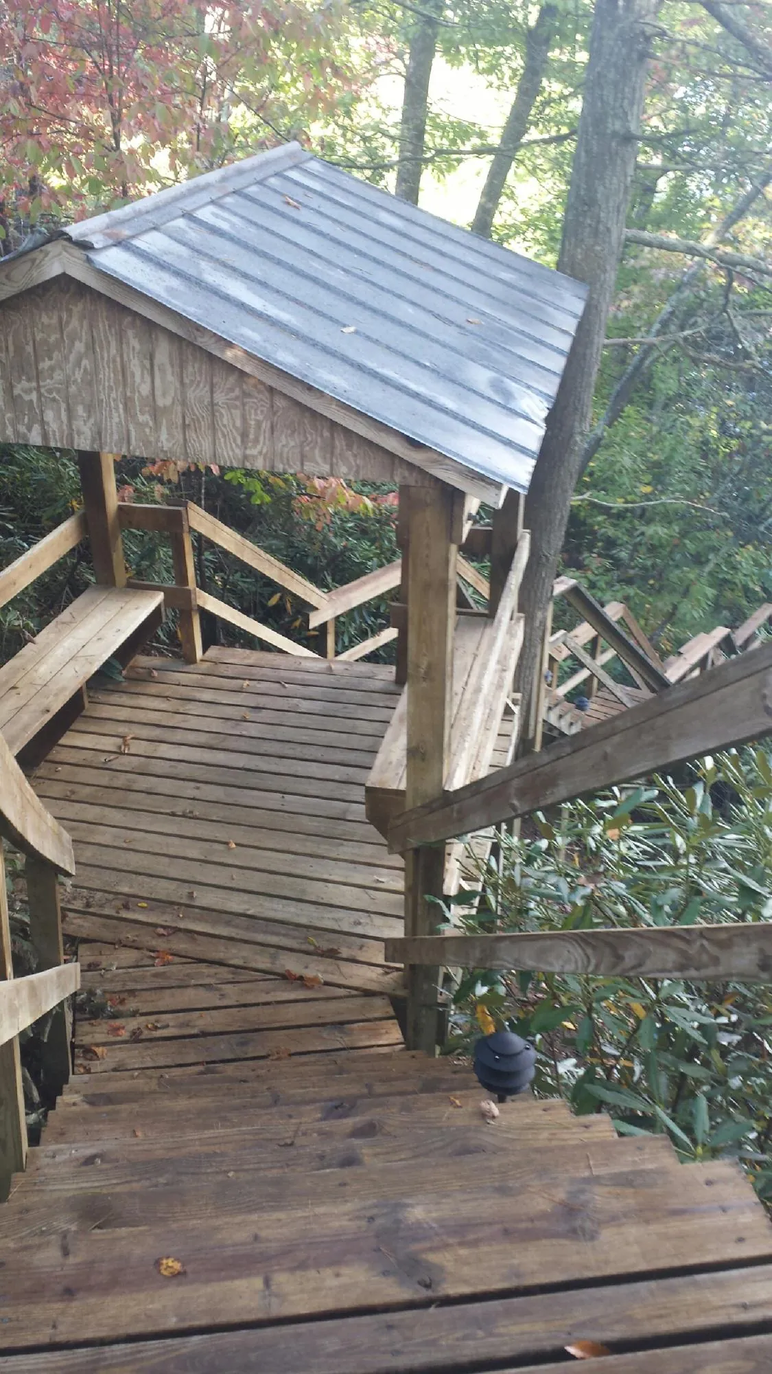 Metal roofed shelter over wooden steps on a wooded walkway — Skylight Repair & Installation work by our crew in Goldvein