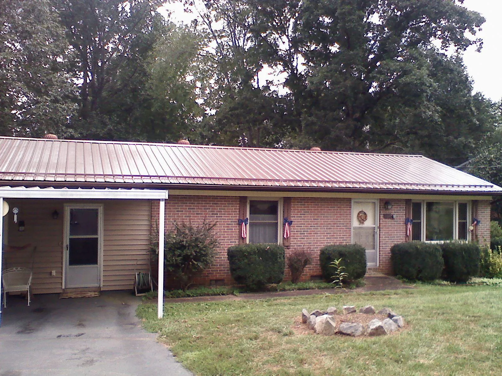 Bronze metal roof and carport on a brick ranch home — Roof Repair work by our crew in Goldvein
